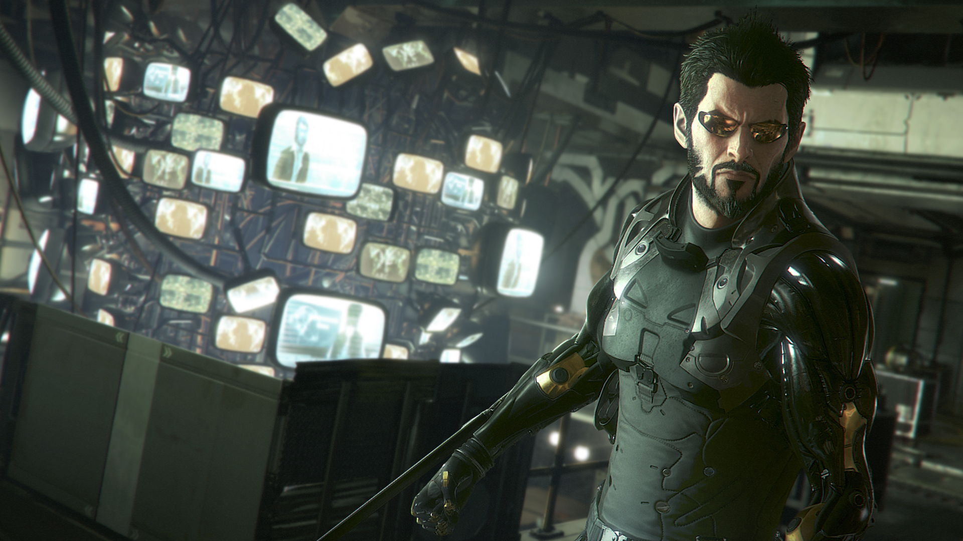 A screenshot from "Deus Ex: Mankind Divided:" character Adam Jensen, wearing a black bodysuit, before a row of TV screens