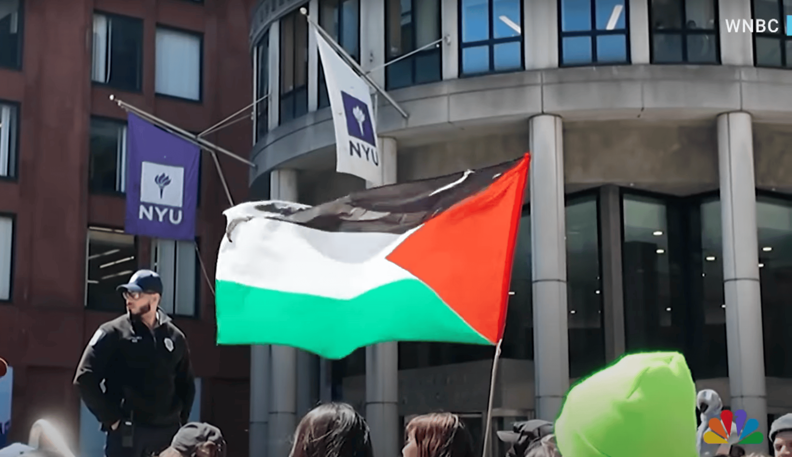 A Palestinian flag waves in front of flags for NYU
