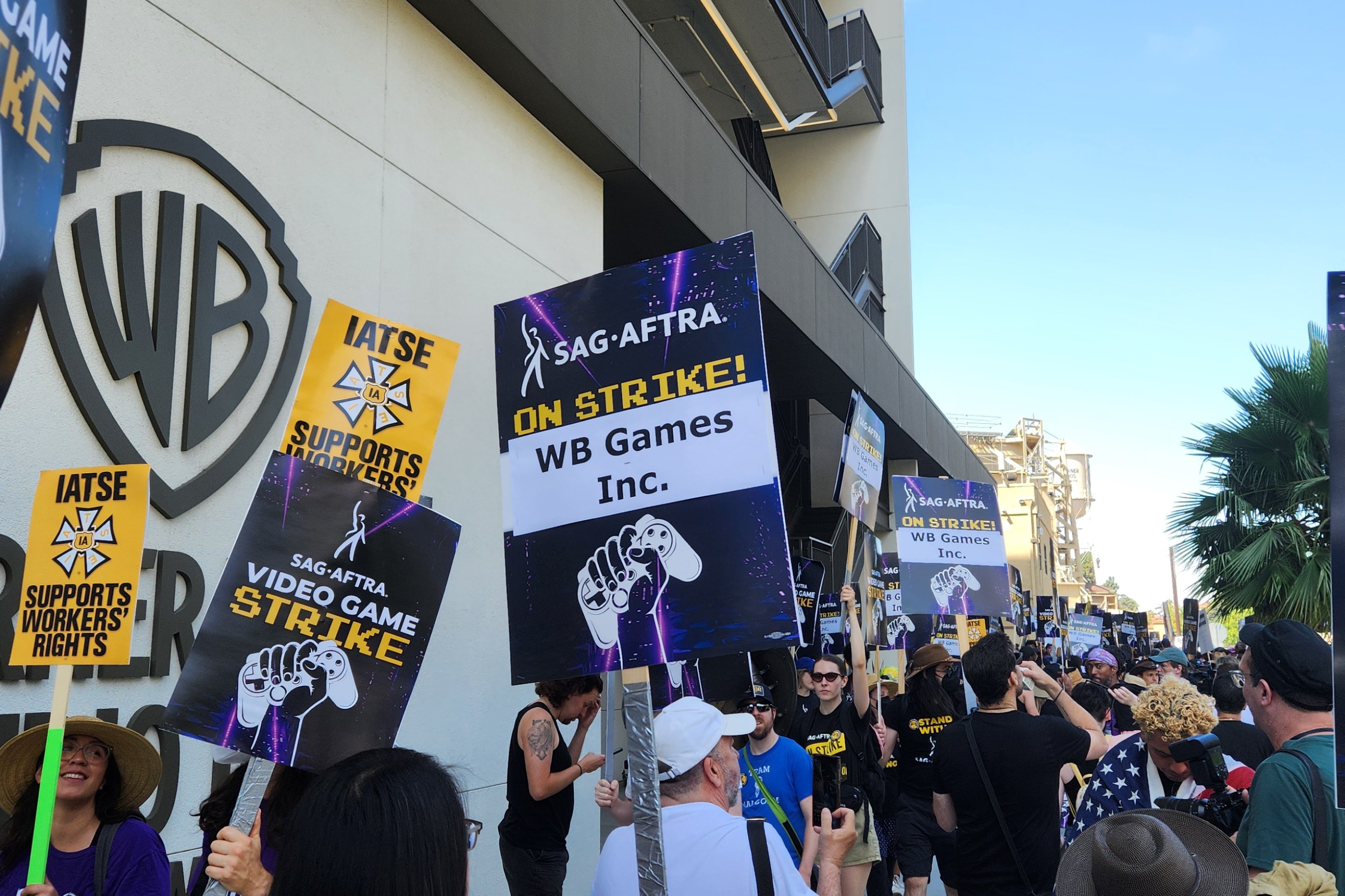 SAG-AFTRA picketers holding signs outside WB Studios