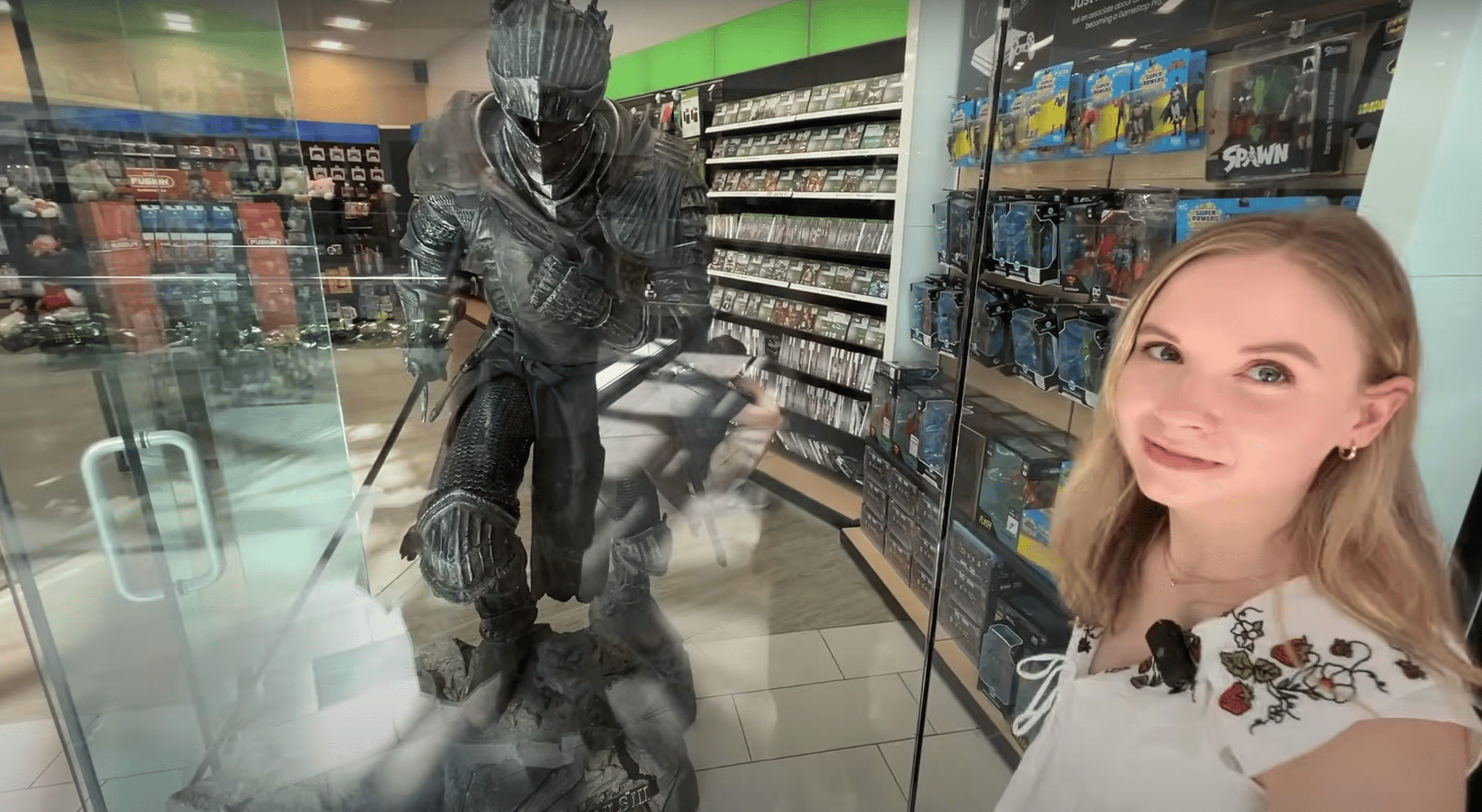 MinnMax's Sarah Podzorski stands next to a statue from Dark Souls at a GameStop