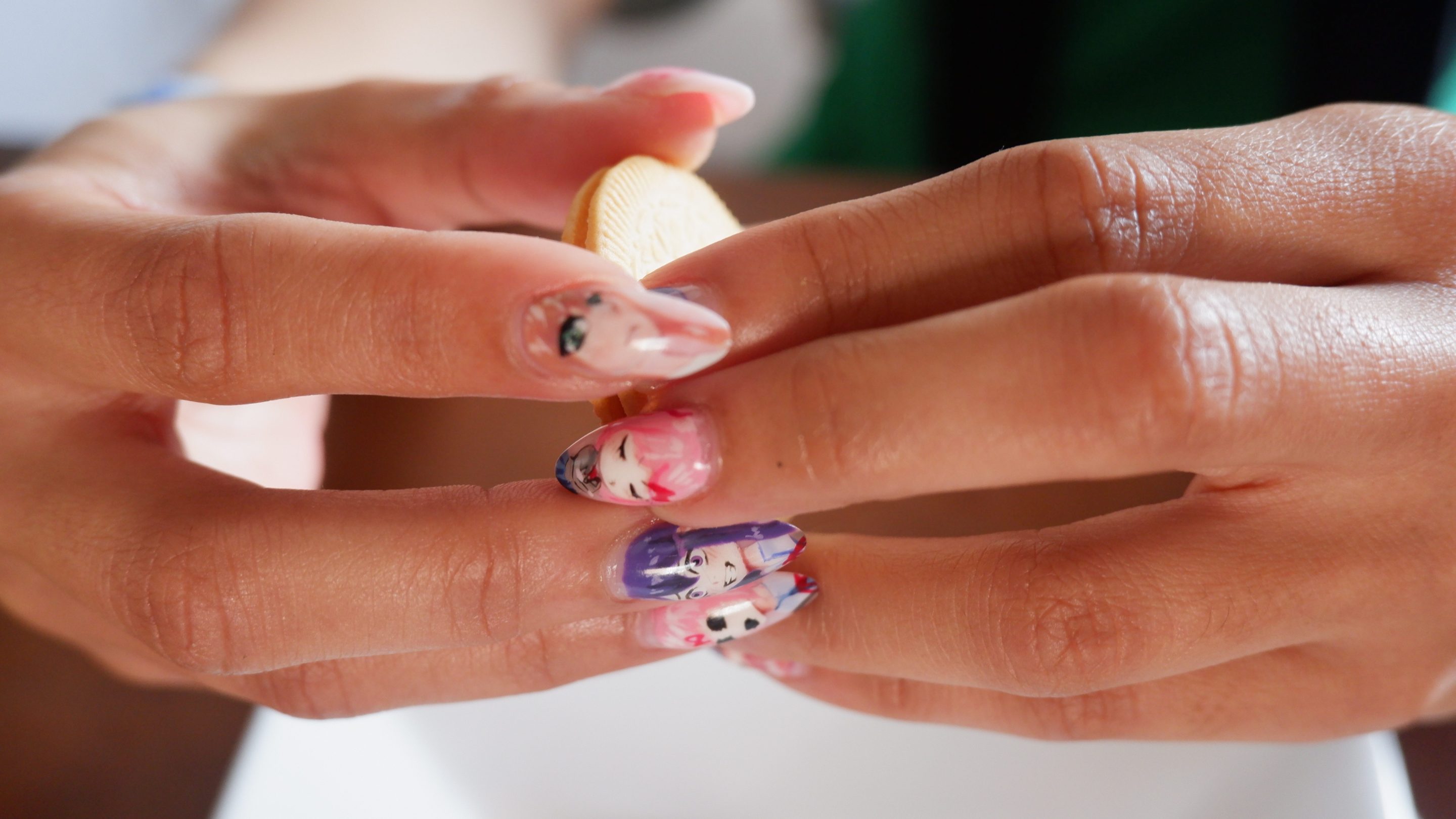 Hands with Doki Literature Club nails holding Oreos.