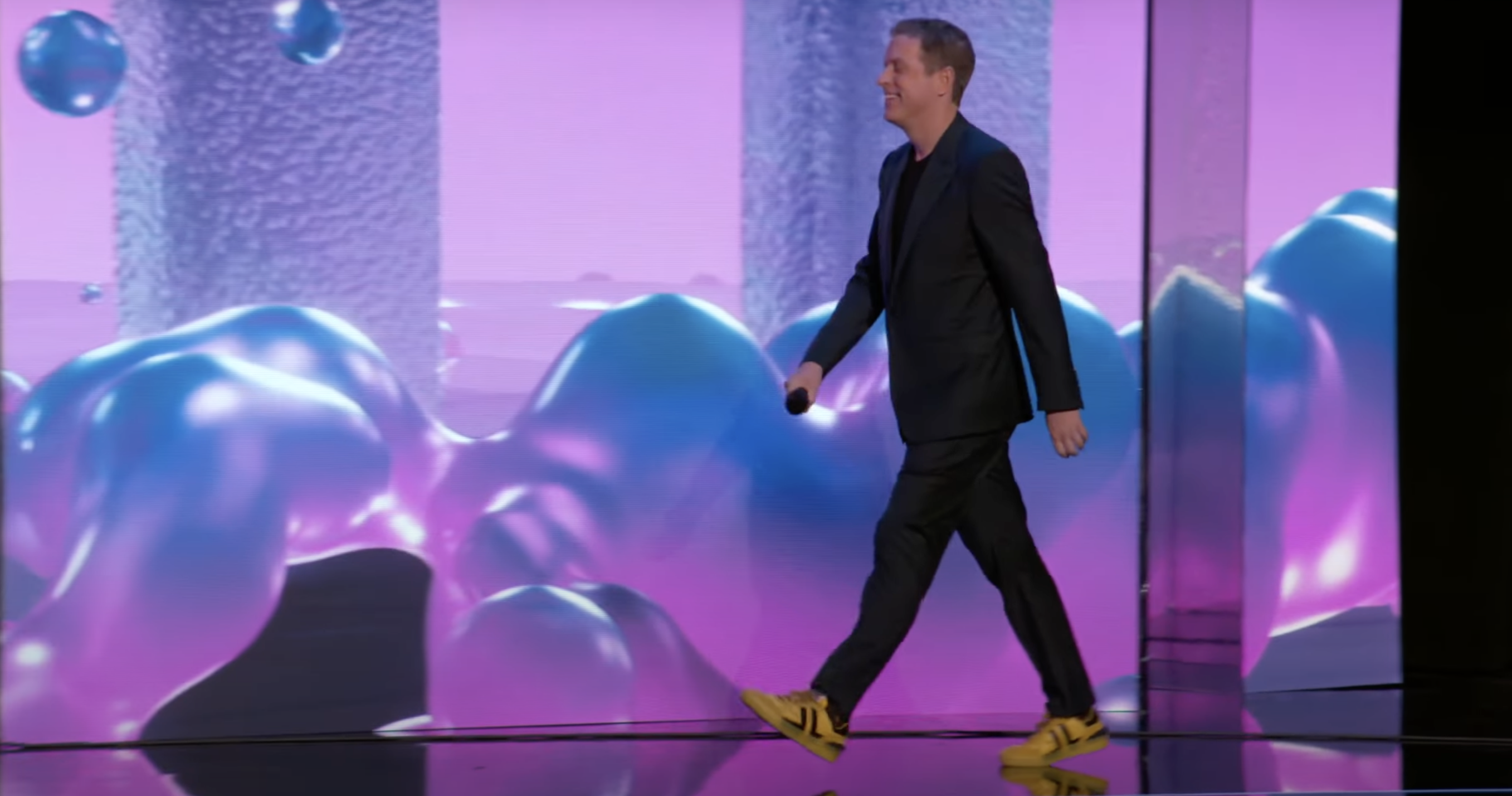 Geoff Keighley on stage at Summer Game Fest, wearing yellow sneakers