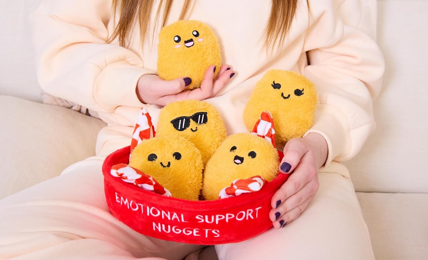 A person in beige loungewear holding a basket of stuffed chicken nuggets