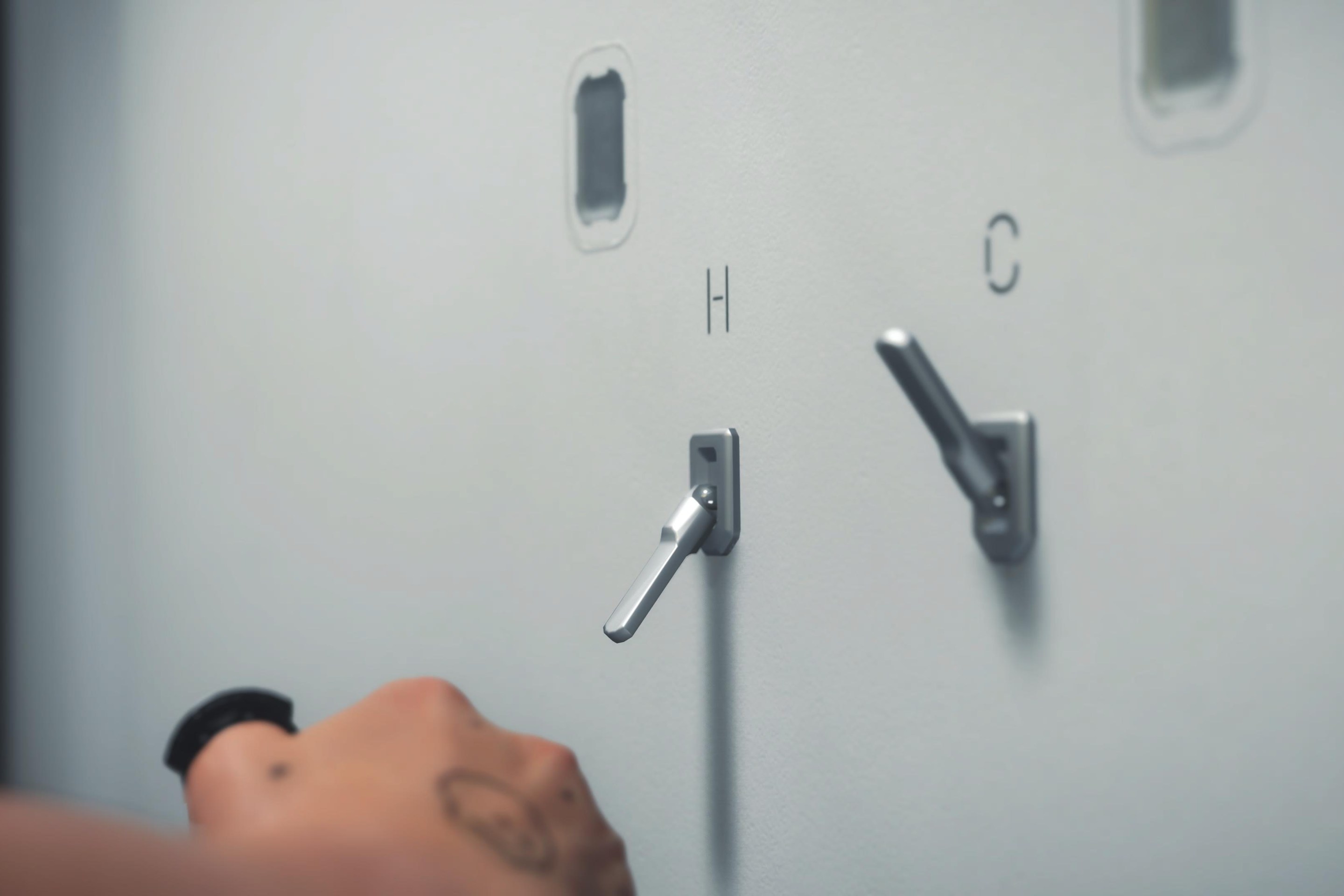 The shower handles in Death Stranding 2, which appear to be the same in Death Stranding 1. They are hot and cold switches labeled "H" and "C".
