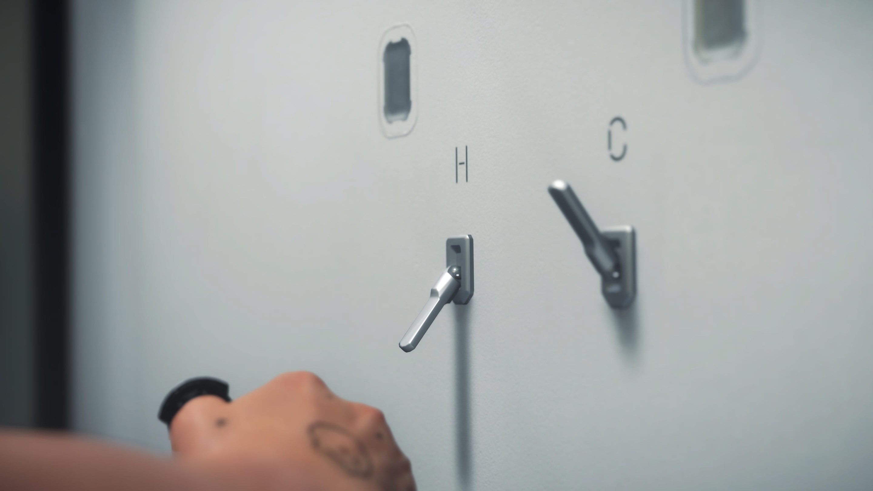 The shower handles in Death Stranding 2, which appear to be the same in Death Stranding 1. They are hot and cold switches labeled "H" and "C".