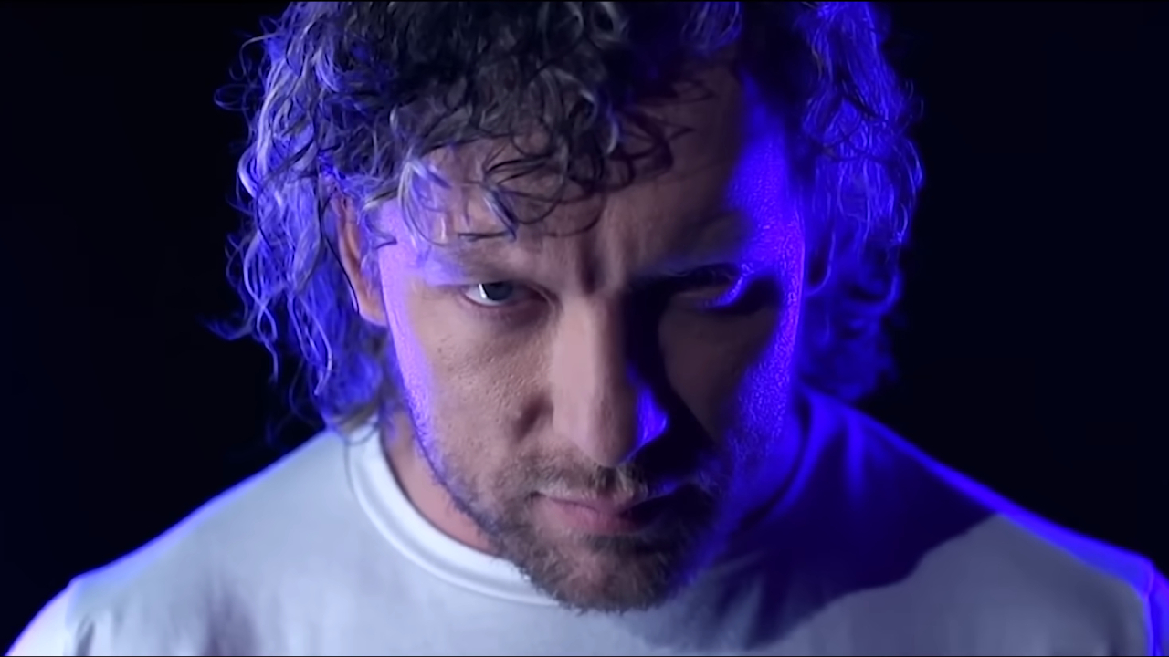 AEW wrestler Kenny Omega posing in blue neon lights.
