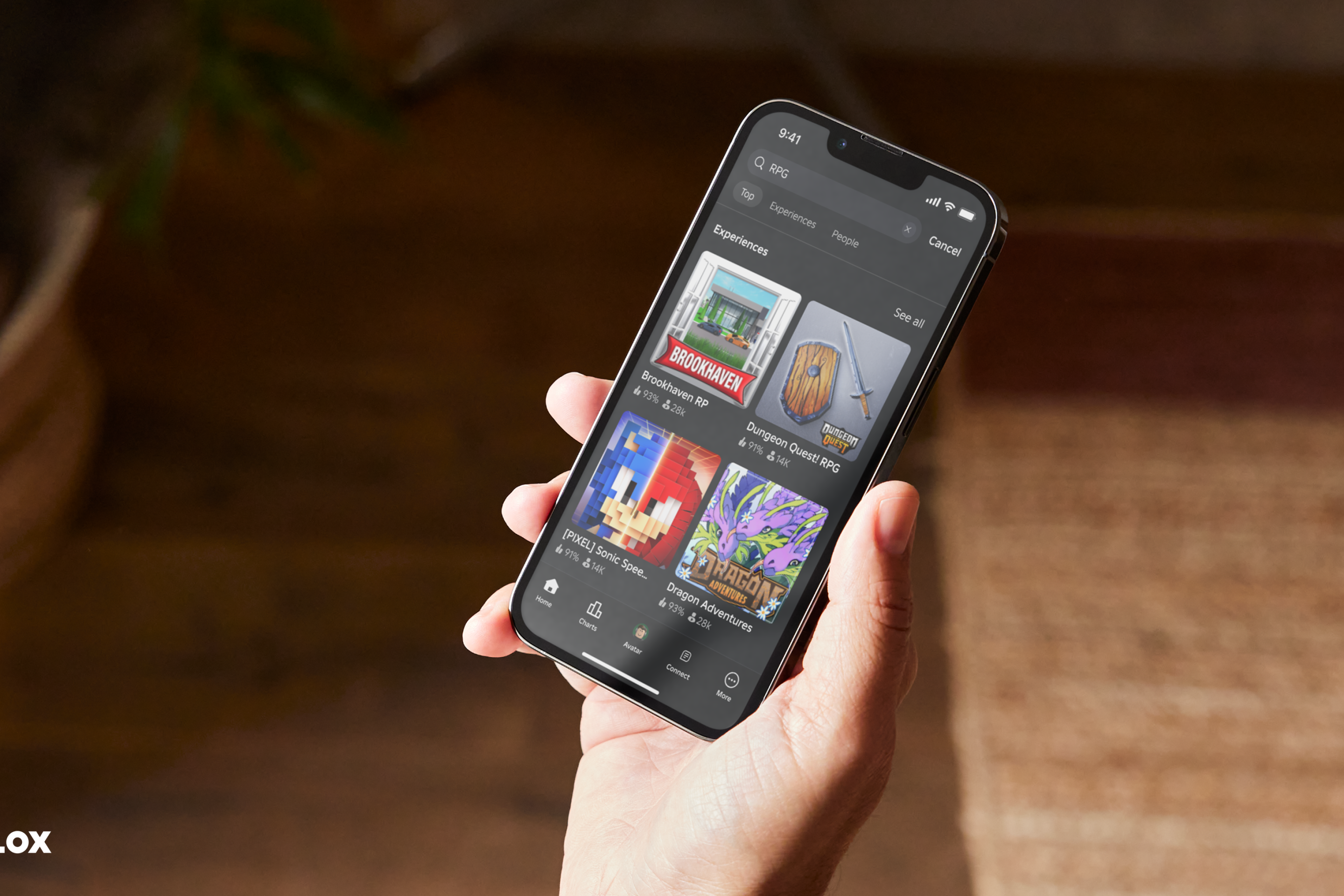 A hand holding a phone that's displaying the Roblox app