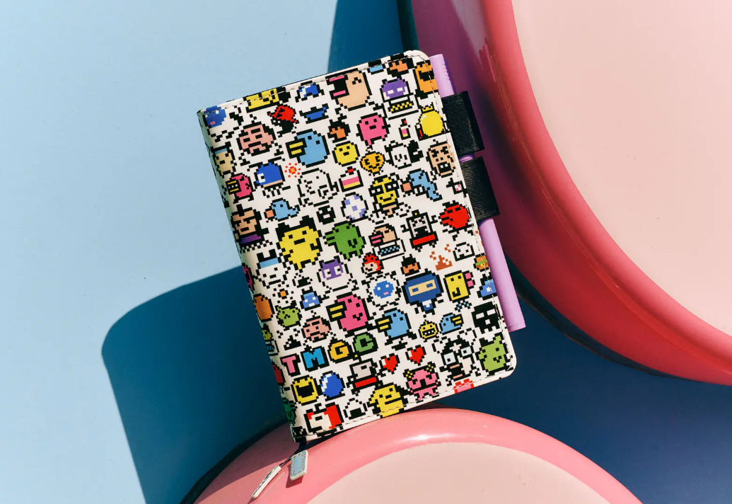 A small planner with a cover that shows all different sorts of Tamagotchi creatures